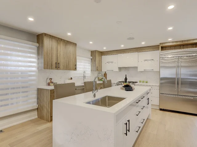white kitchen island with sink inserted and wooden cabinets